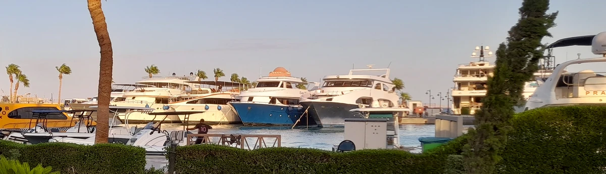Motor yachts tied up along a marina dock at sunset