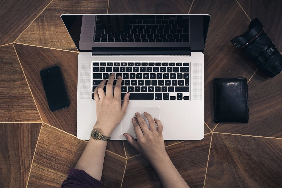 Two hands typing on a laptop keyboard