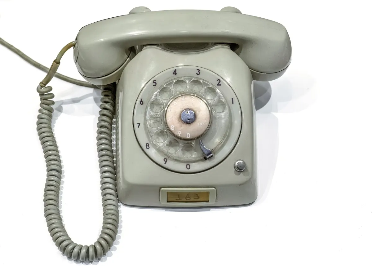 A gray desk telephone with a rotary dial