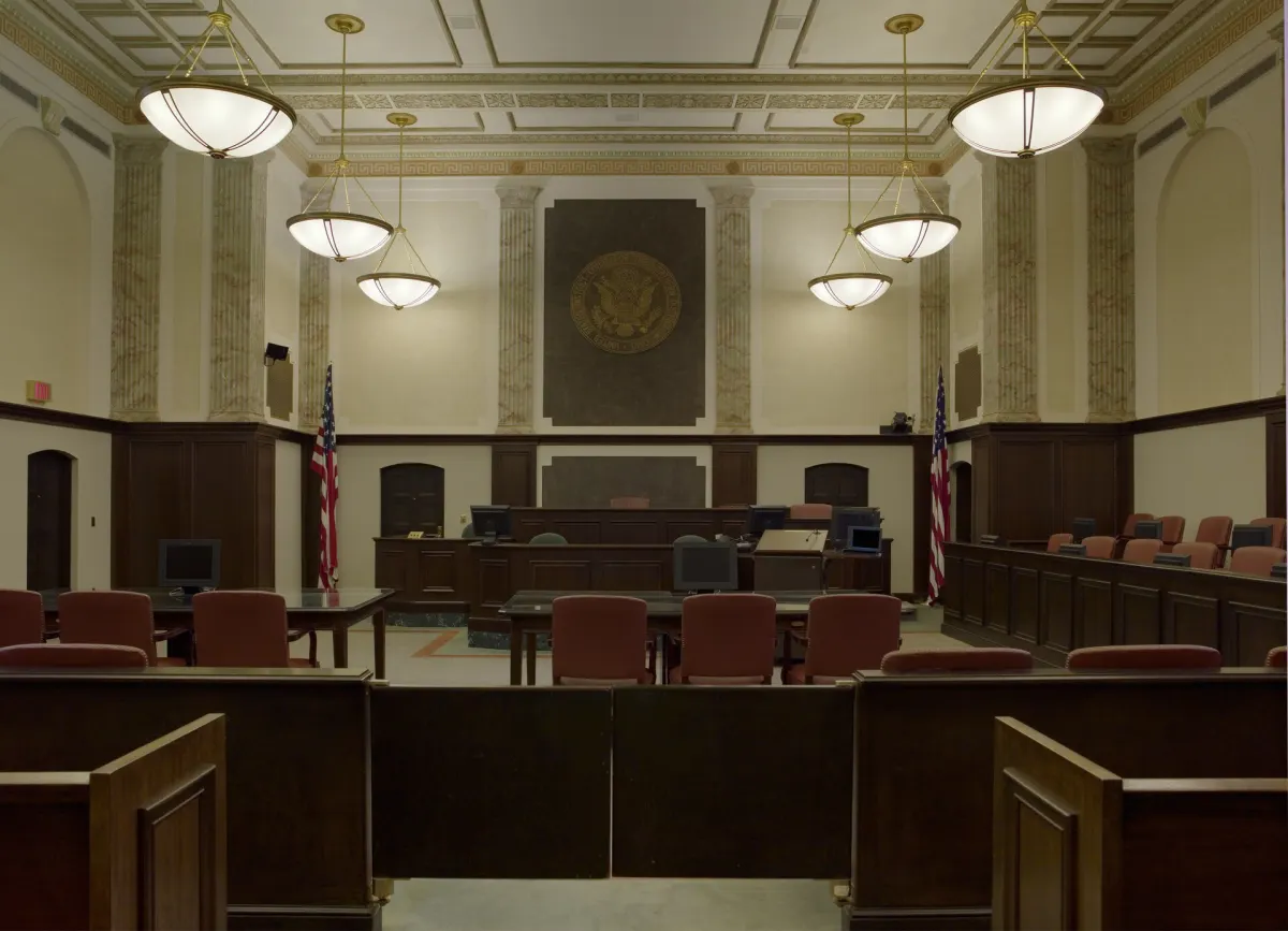 A federal courtroom with a judge's bench and rows of wooden seats