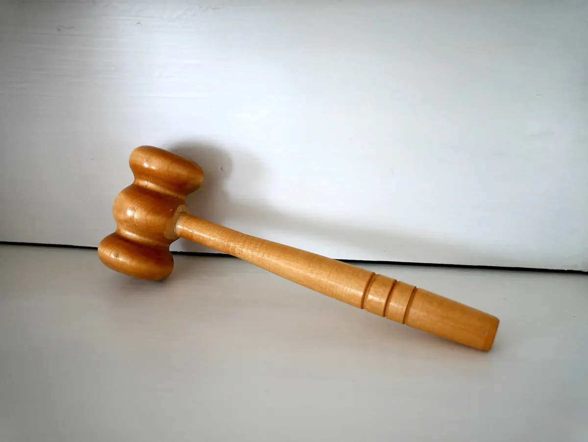 A wooden gavel resting on a white surface