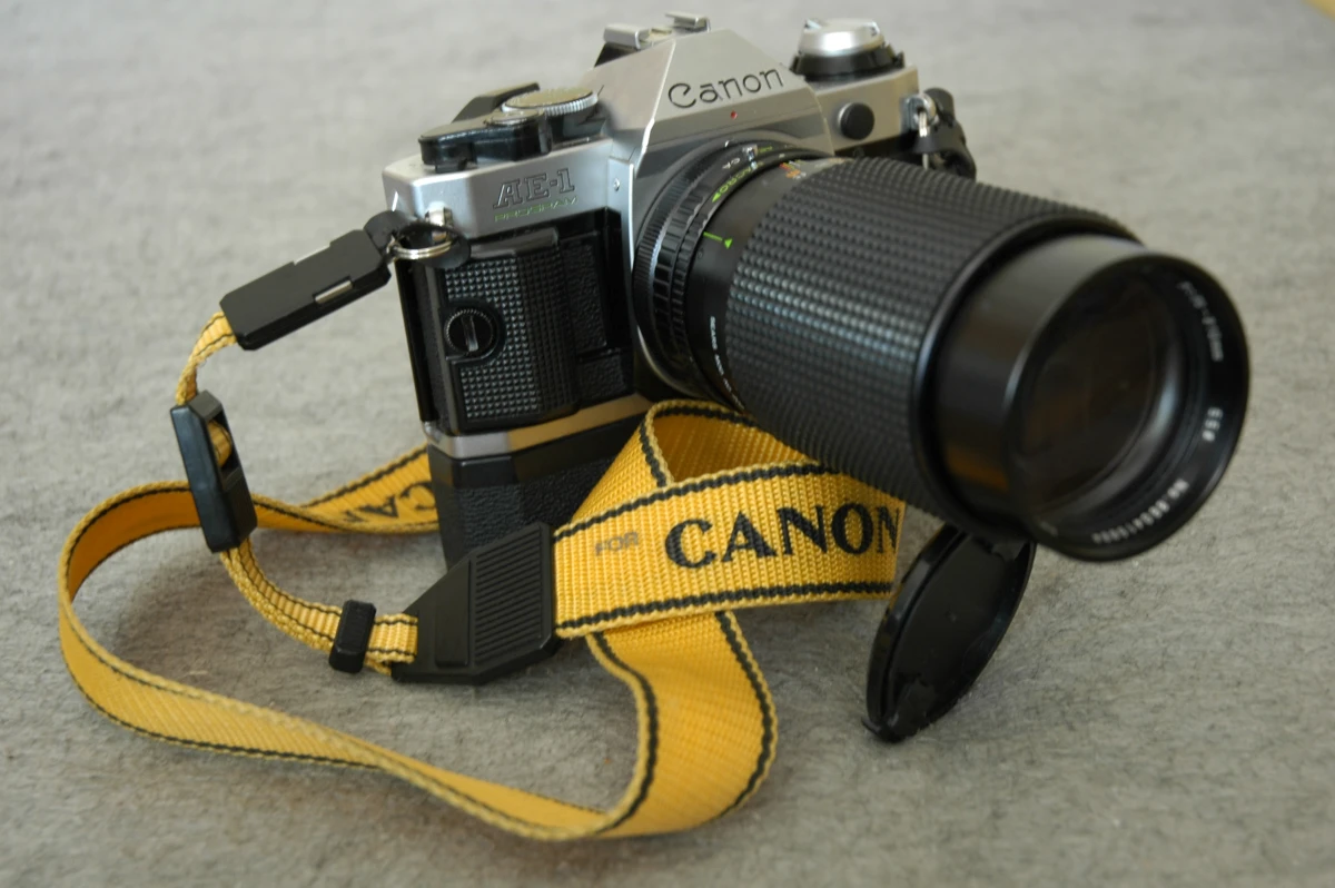 A film camera fitted with a long telephoto zoom lens